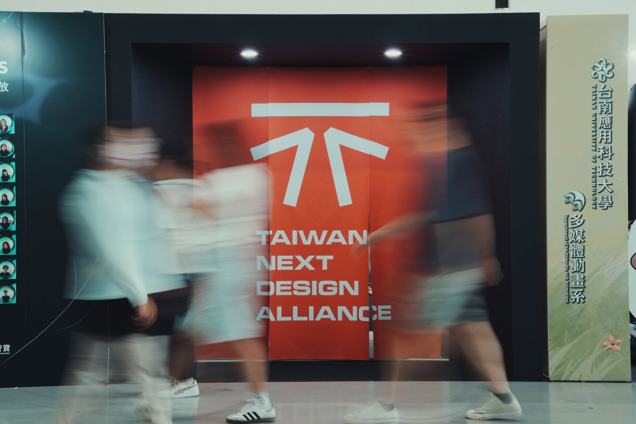 TNDA 品牌識別牆與聯盟學校展位，觀眾川流其間